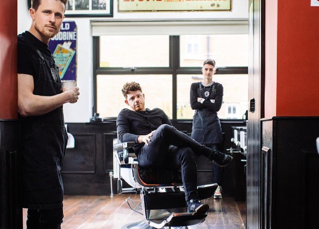 Stylish interior of John at Mulholland Barbering, Portadown, Northern Ireland, GB with three barbers.