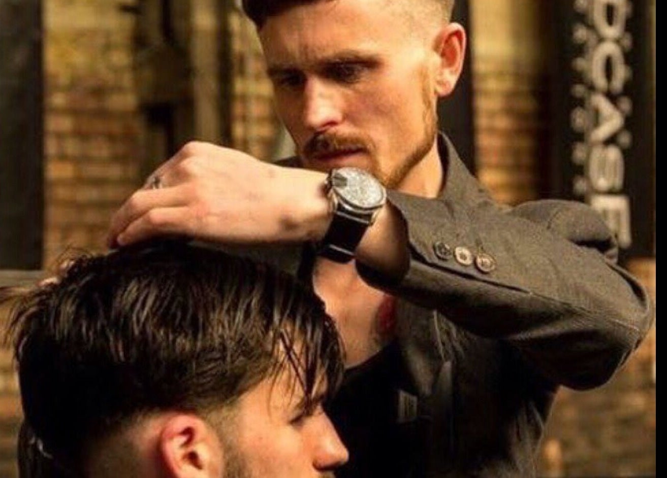 John at Mulholland Barbering in Portadown, Northern Ireland, expertly styling a client's hair with precision.