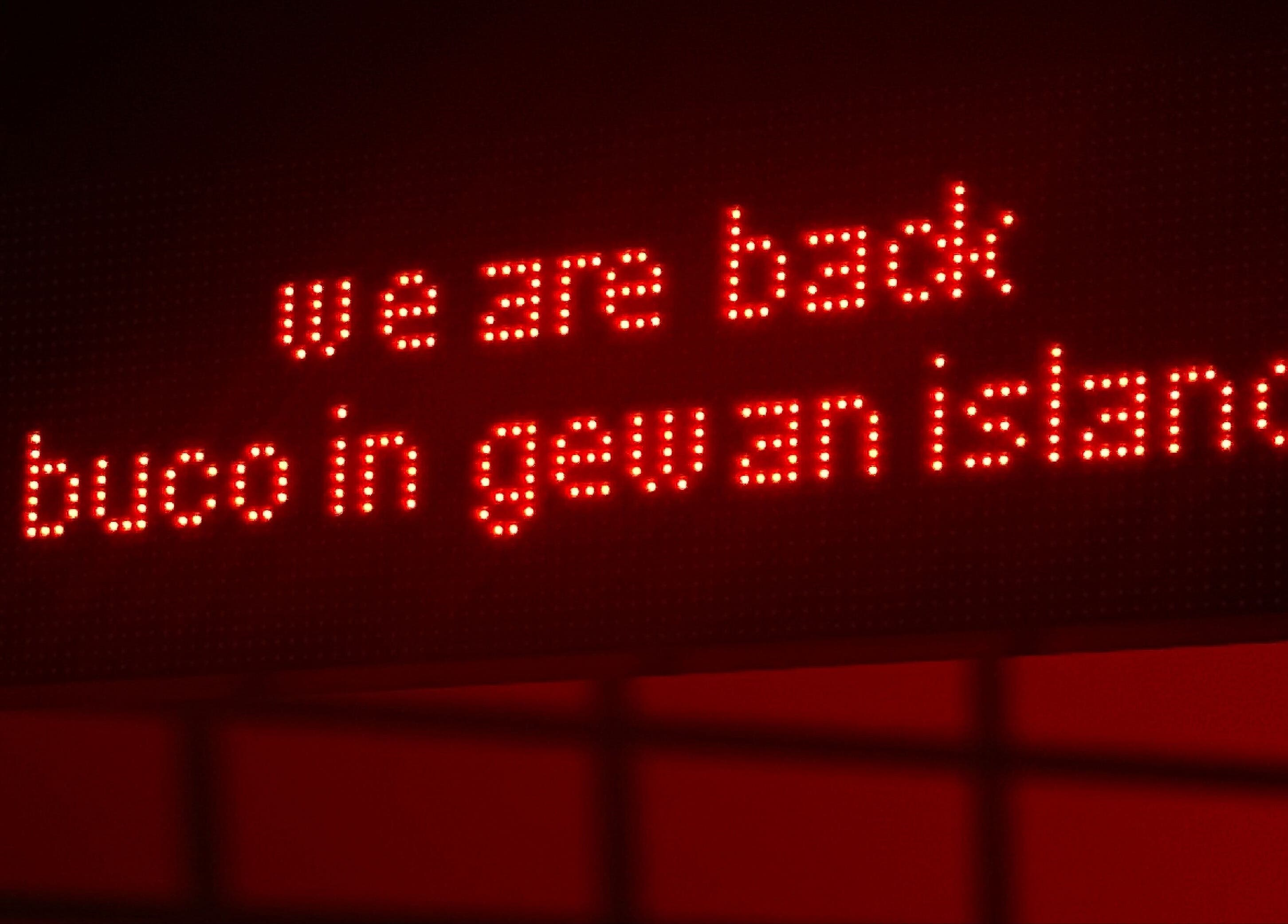 LED sign at Buco Piercing Parlor, Doha, Doha, QA, displaying 'we are back buco in gewan island'.