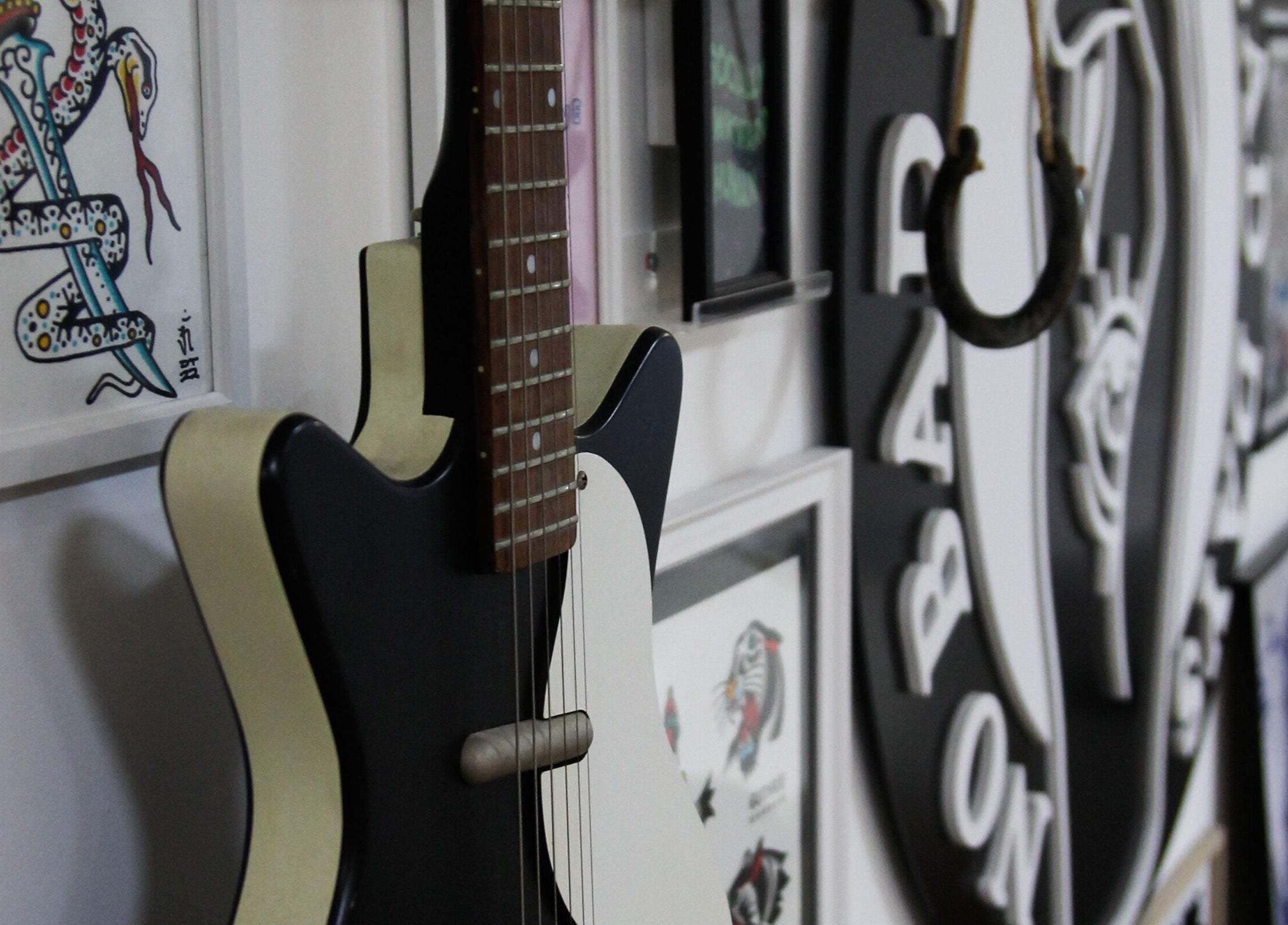 Guitar and vibrant artwork at No Bad Days, Rochester, England, GB enhancing a creative ambiance.