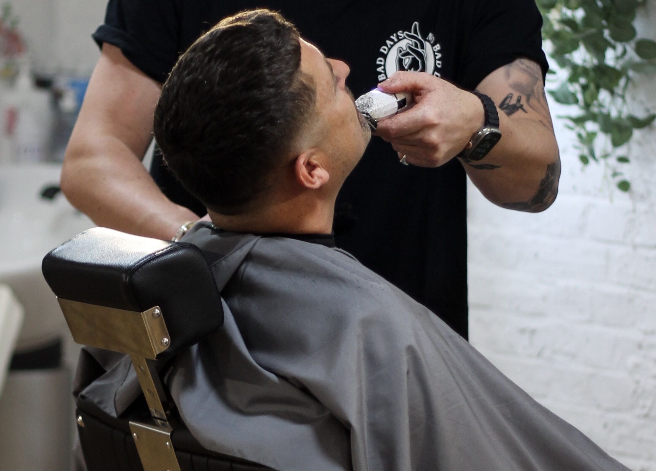 A barber trims a client's beard at No Bad Days, Rochester, England, GB salon.