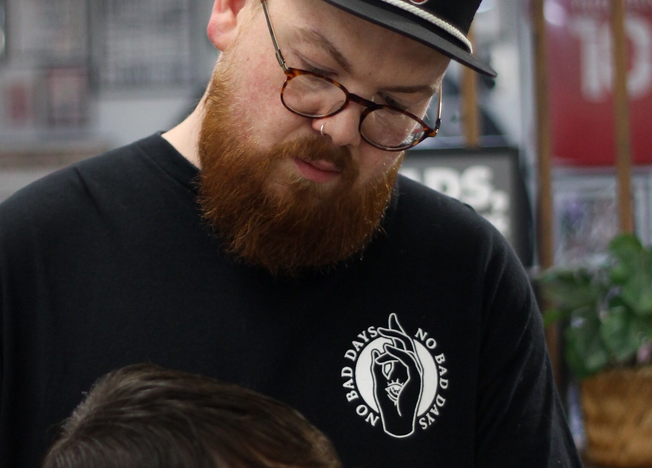 Bearded barber in action at No Bad Days, Rochester, England, GB.