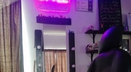 Interior de Yisus Style Barberia en Monterrey, Nuevo León, MX con silla y espejo iluminado por luz neón.