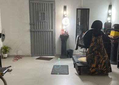 Interior moderno de Yisus Style Barberia en Monterrey, Nuevo León, MX, mostrando silla de barbero y espejos iluminados.