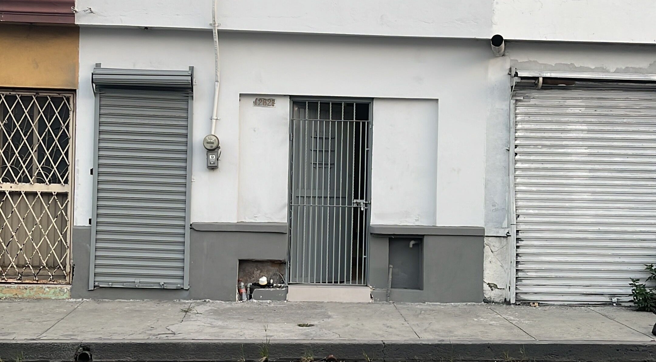 Fachada de Yisus Style Barberia en Monterrey, Nuevo León, MX, con puerta y cortinas metálicas.