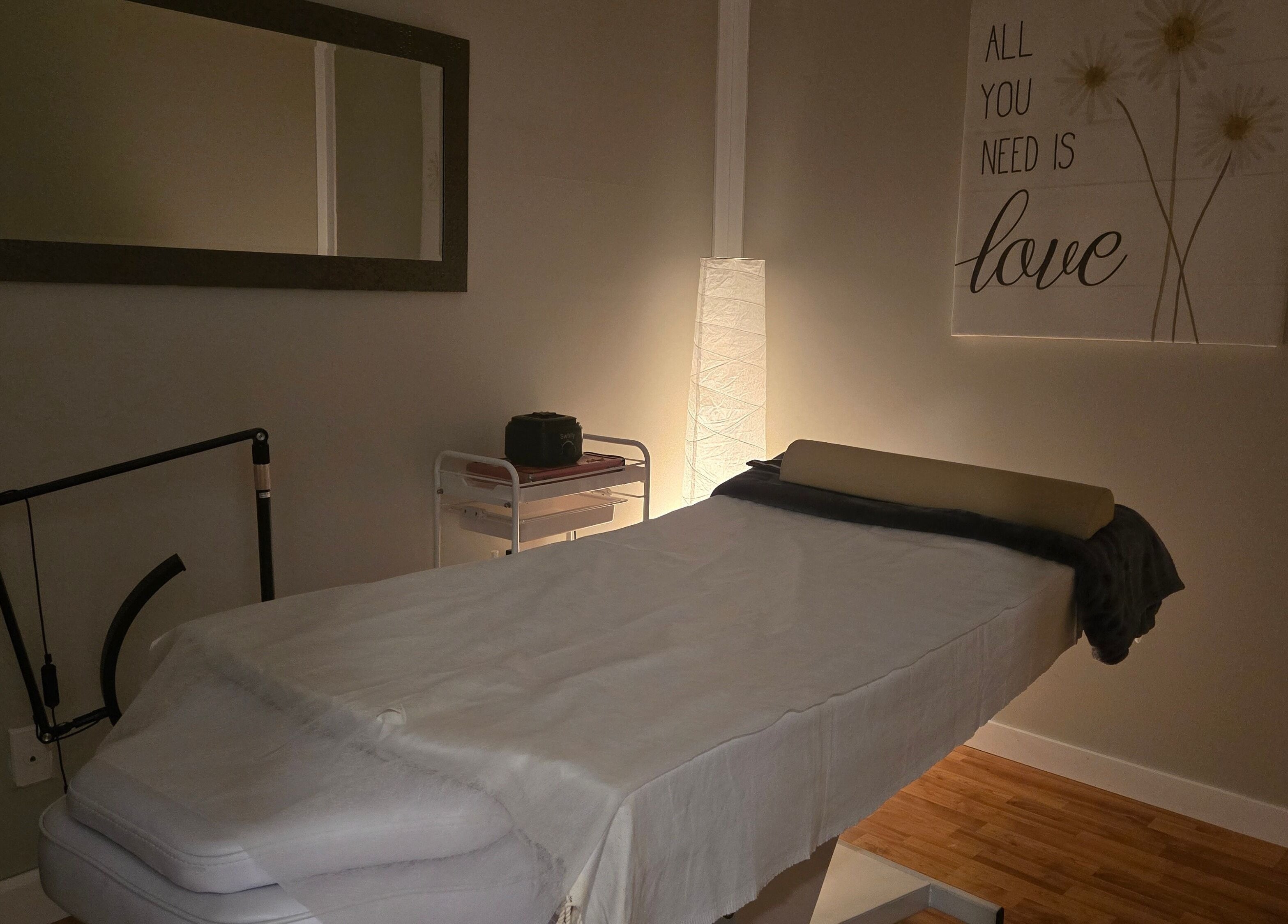 Relaxing massage room at Tree Treat Spa, Kawartha Lakes, Ontario, CA, featuring a cozy treatment bed and soft lighting.