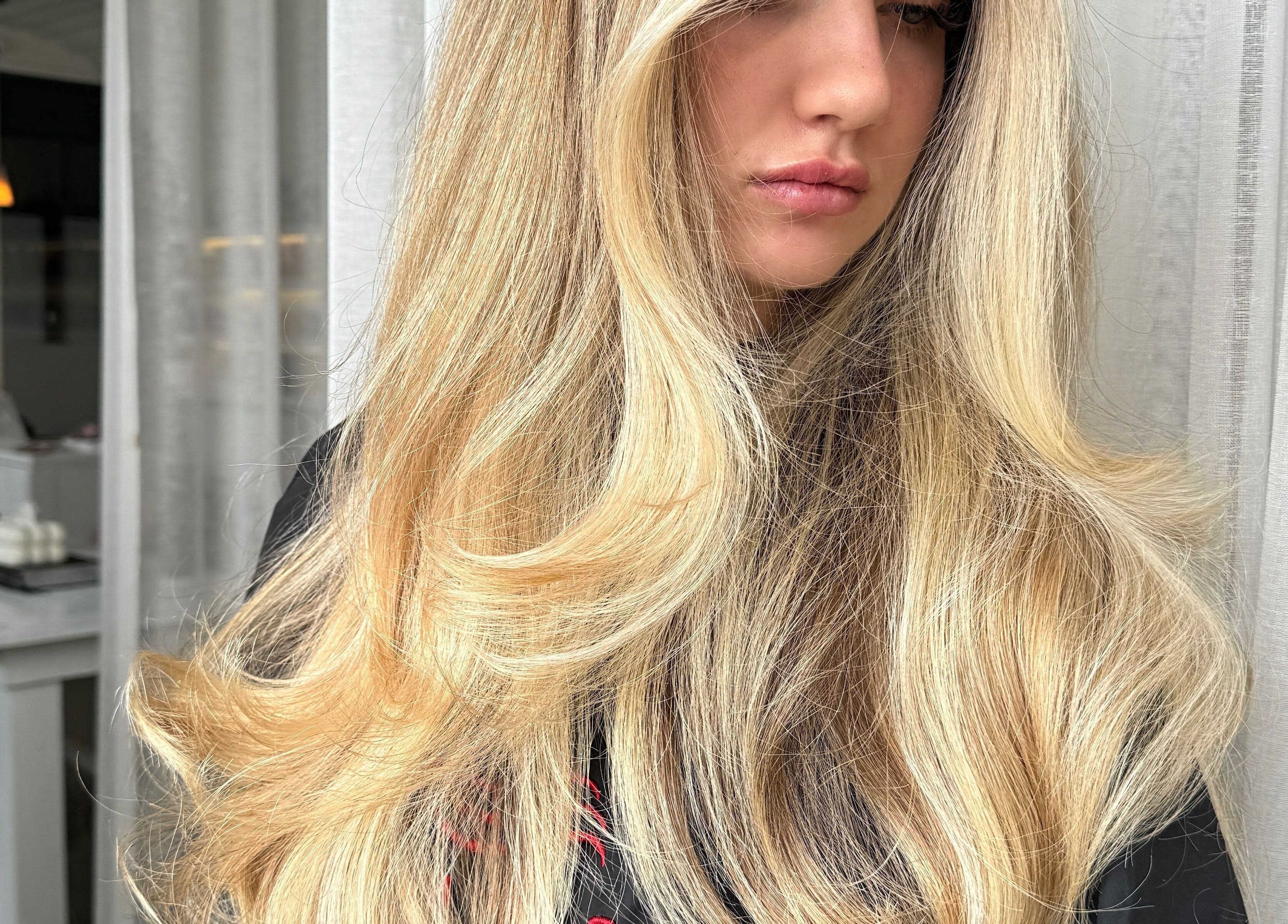 A woman with flowing blonde hair at Rinsd Hair, Palm Beach, Queensland, AU, showcasing a stylish hair treatment.