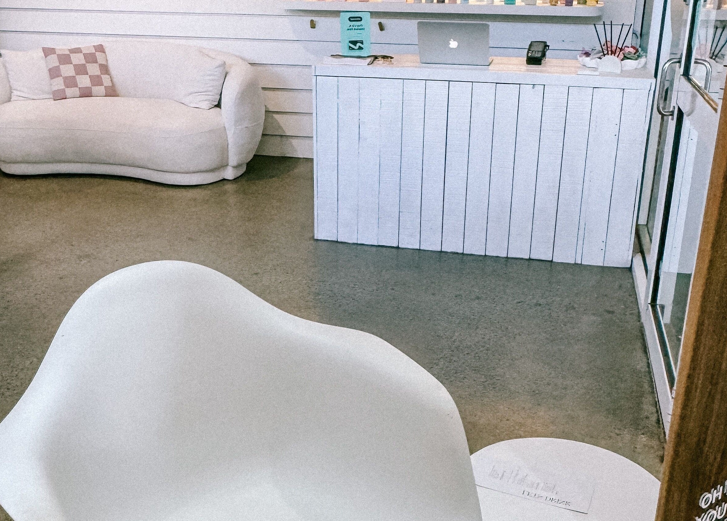 Chic seating area at Rinsd Hair in Palm Beach, Queensland, AU, featuring modern white decor.