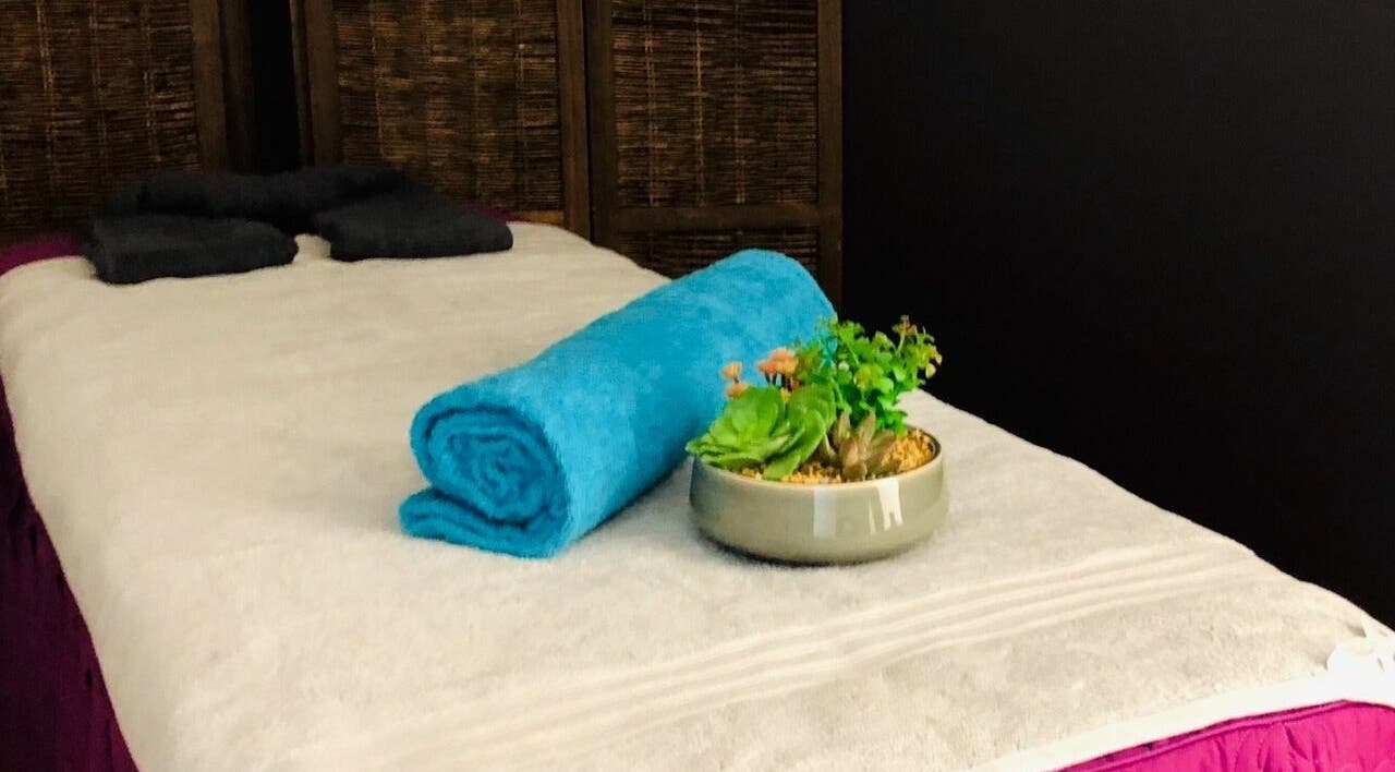 Massage bed at Oceanic Spa Moonah in Moonah, Tasmania, AU with blue towel and plant accent.