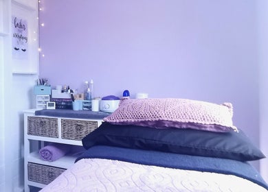 Relaxing treatment room at Nova Bella Beauty, Cape Town, Western Cape, ZA, with soft purple hues and cozy atmosphere.