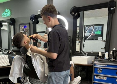 Barber styling client's hair at The Barbers Bru in Albury, New South Wales, AU with modern decor.