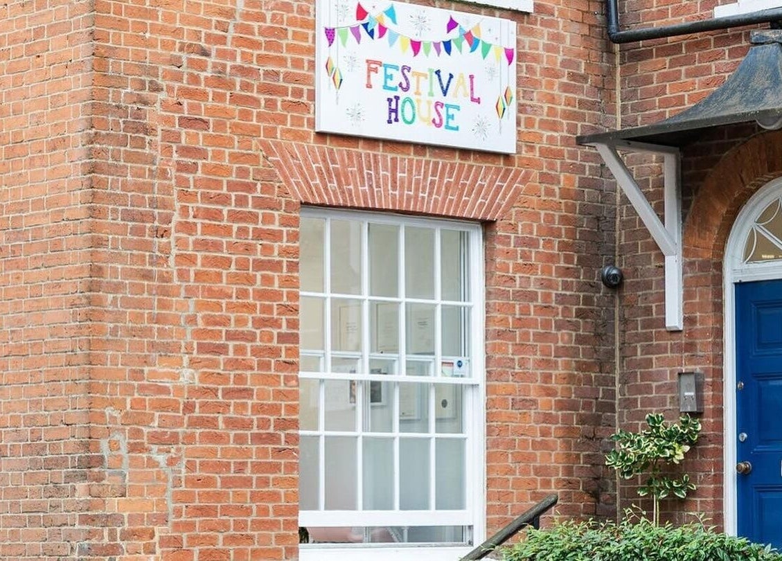 Festival House entrance near Victoria Alice Brows in Newbury, England, GB. Bright blue door with red brick exterior.