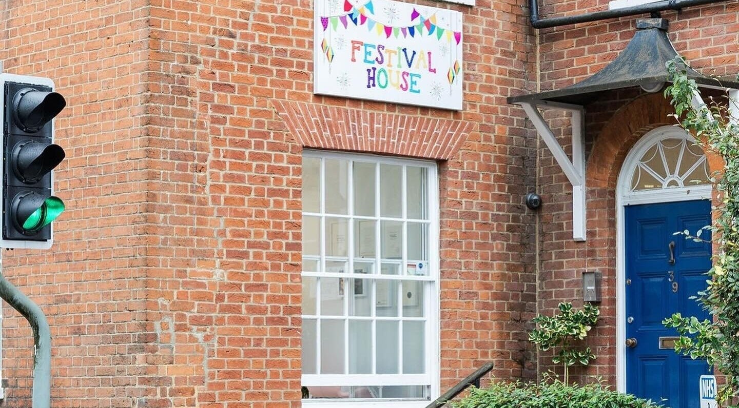Festival House entrance near Victoria Alice Brows in Newbury, England, GB. Bright blue door with red brick exterior.