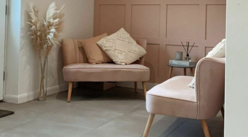 Chic seating area at Bethany’s Hair Studio, Dudley, England, GB, featuring stylish pink couches and decor.