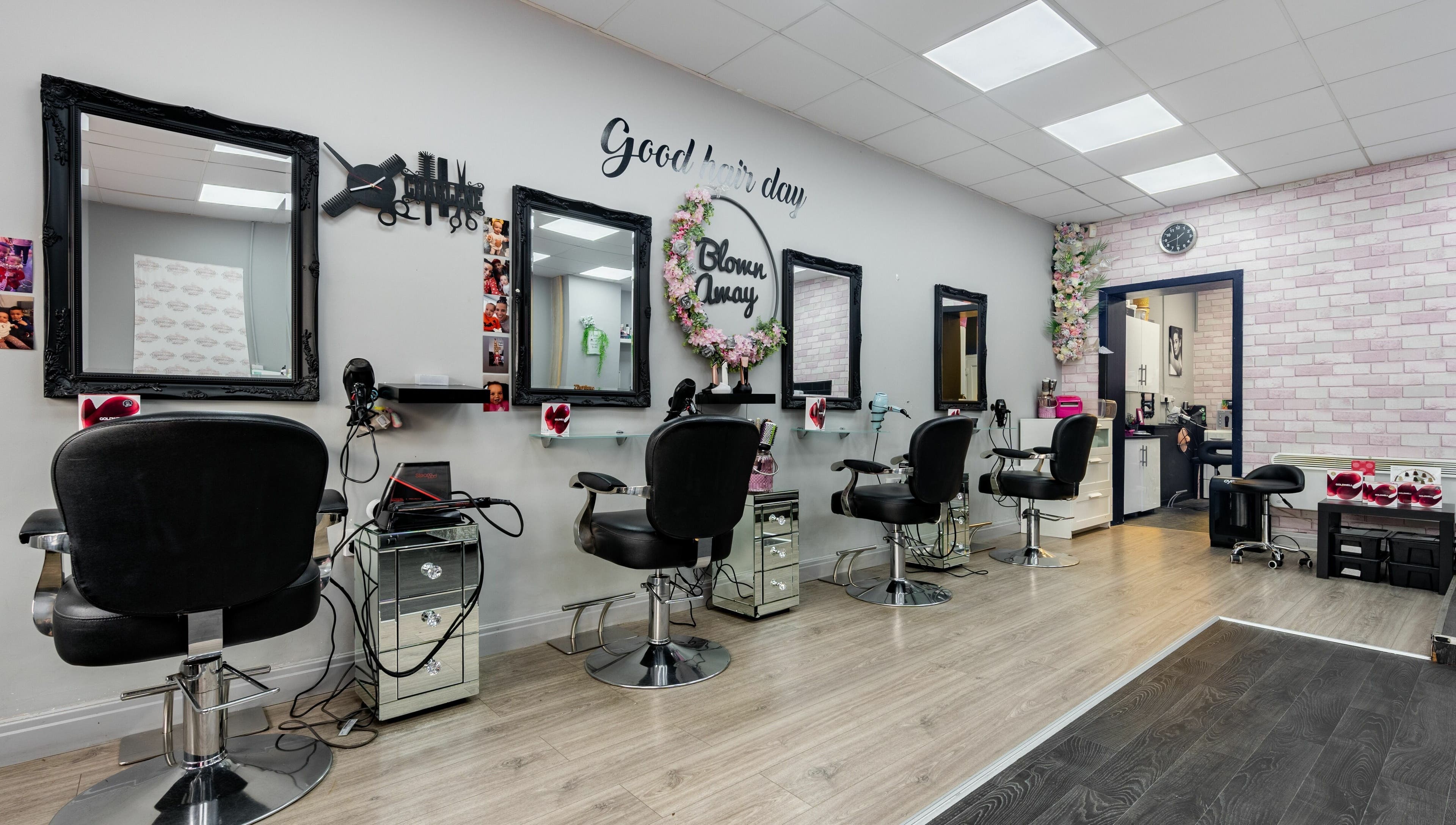Elegant salon interior at Blown Away, Wythenshawe, England, GB, featuring stylish black chairs and mirrors.