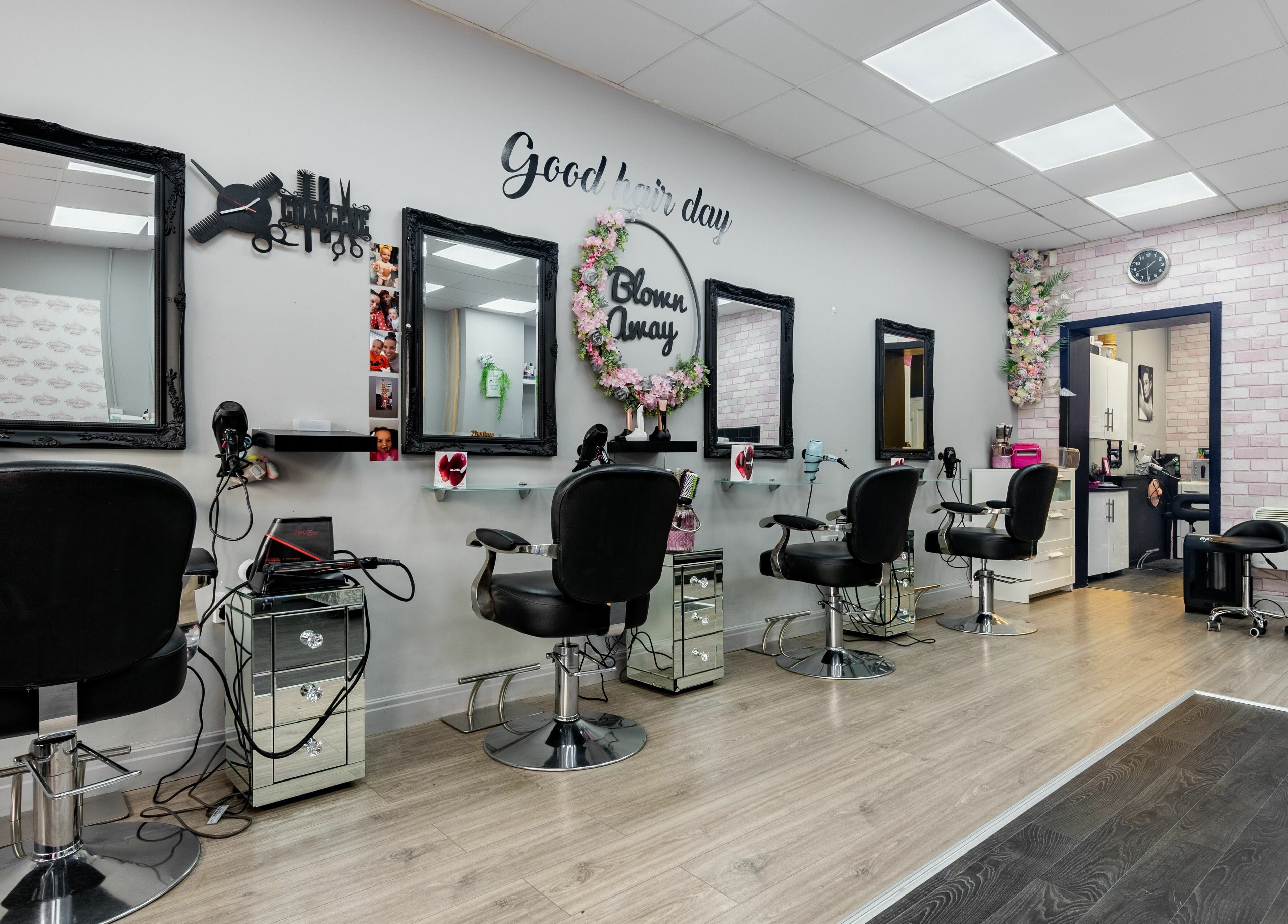 Elegant salon interior at Blown Away, Wythenshawe, England, GB, featuring stylish black chairs and mirrors.