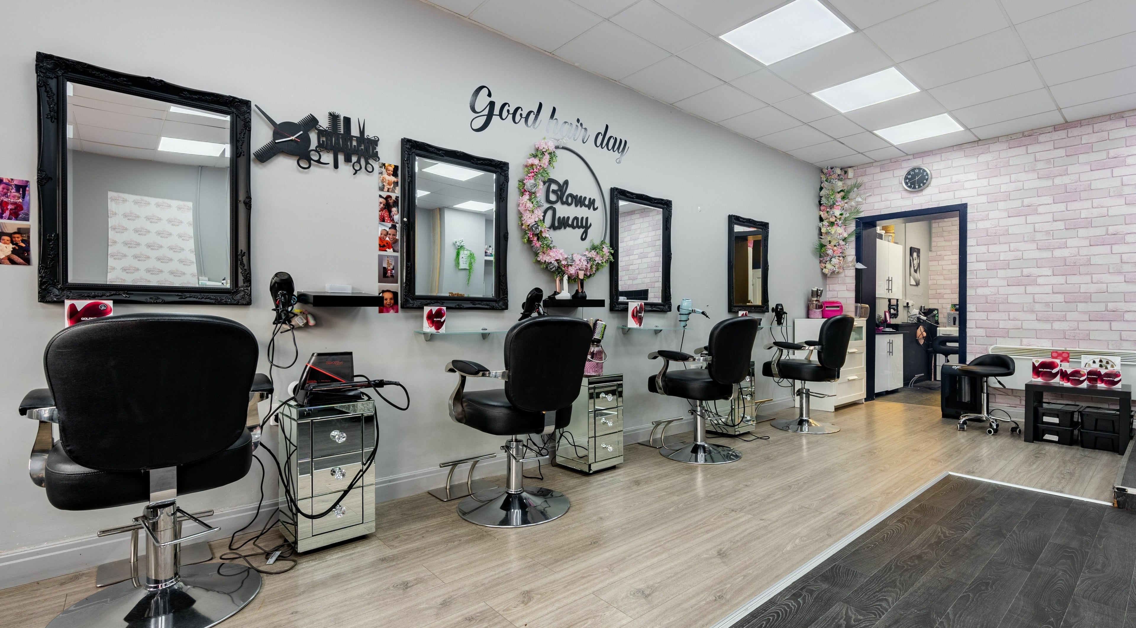 Elegant salon interior at Blown Away, Wythenshawe, England, GB, featuring stylish black chairs and mirrors.