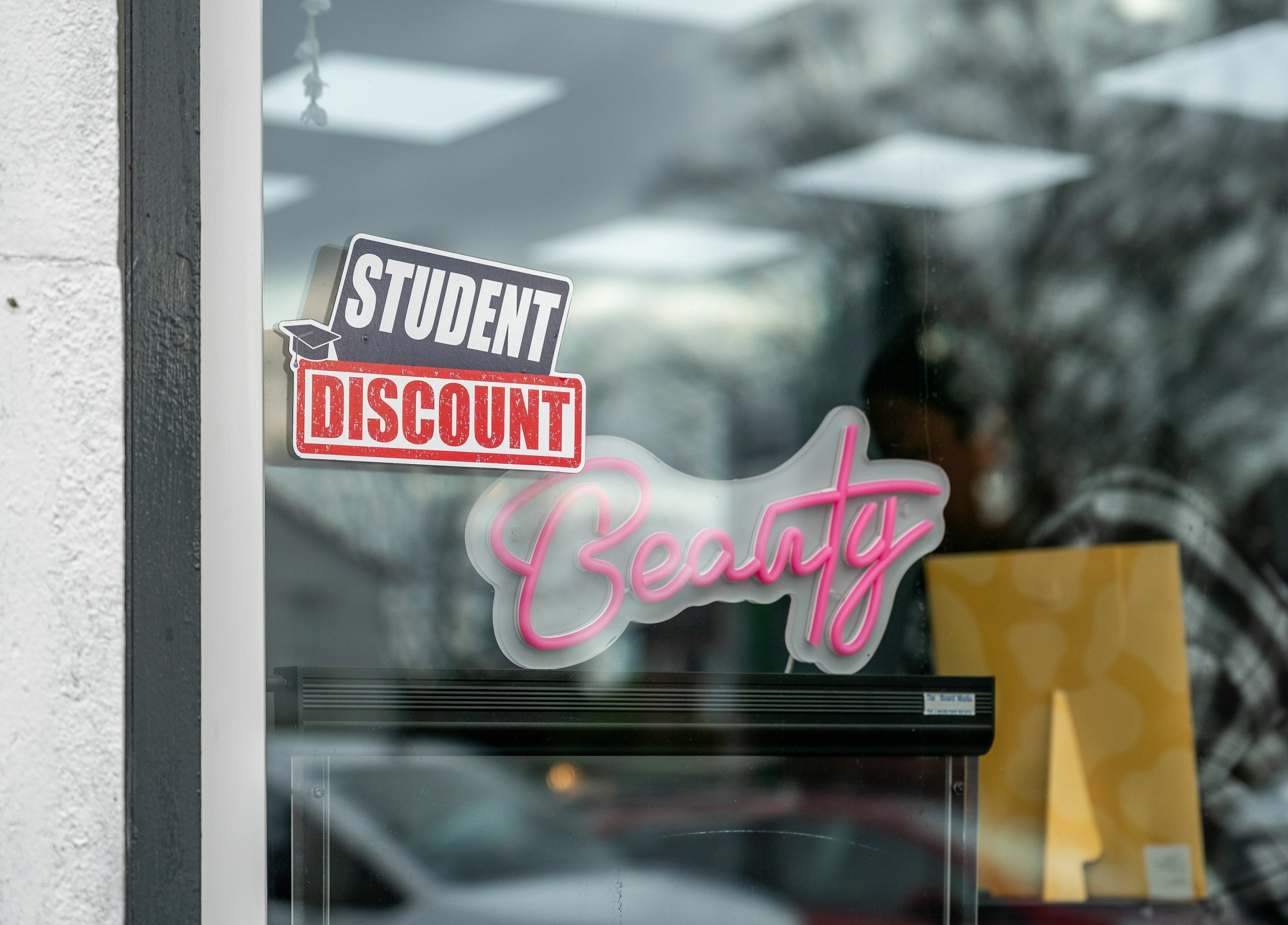 Blown Away in Wythenshawe, England, GB offers student beauty discounts in store window display.