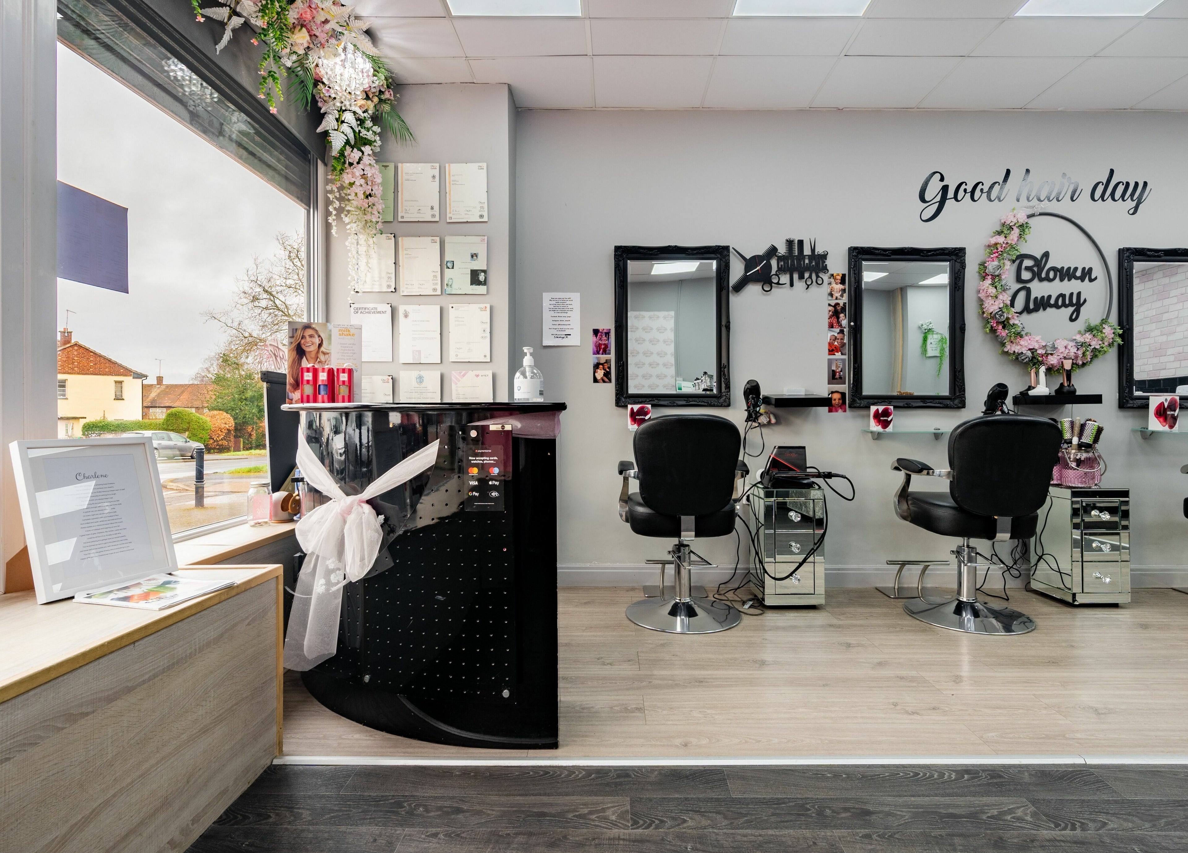 Interior of Blown Away salon in Wythenshawe, England with stylish hair stations and floral decor.