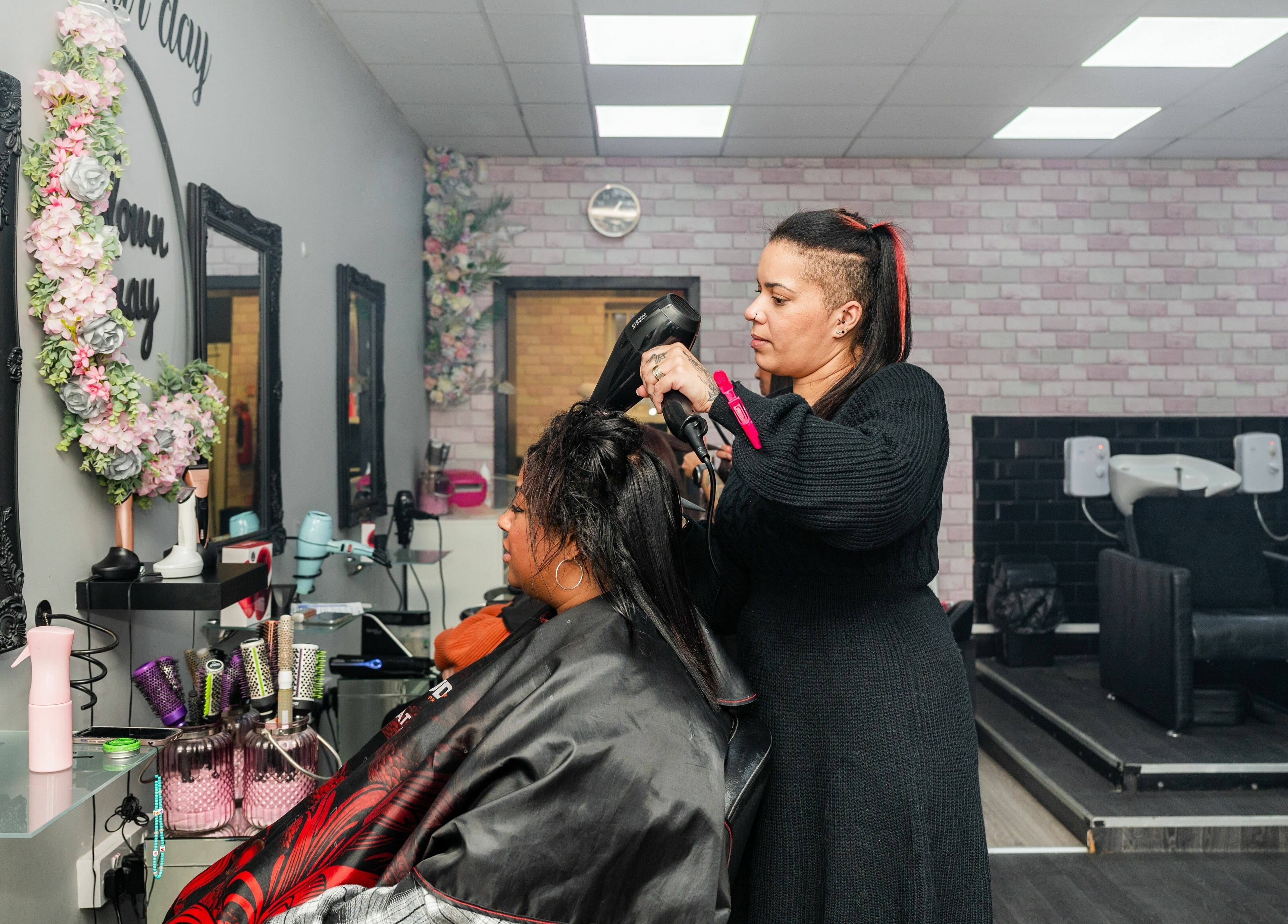 Hairdresser styling client at Blown Away, Wythenshawe, England, GB. Modern salon ambiance.