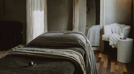 A serene treatment room at UMICA, Byron Bay, New South Wales, AU featuring a cozy bed and elegant decor.