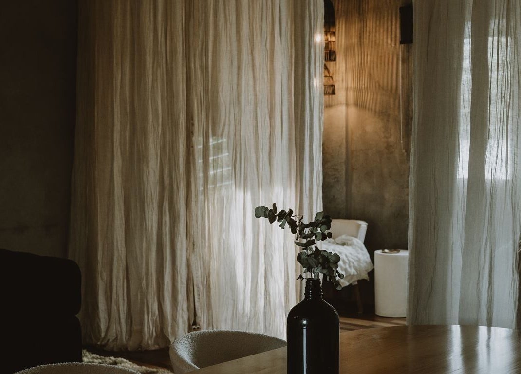 Elegant, cozy room at UMICA, Byron Bay, New South Wales, AU with ambient lighting and soft drapery.