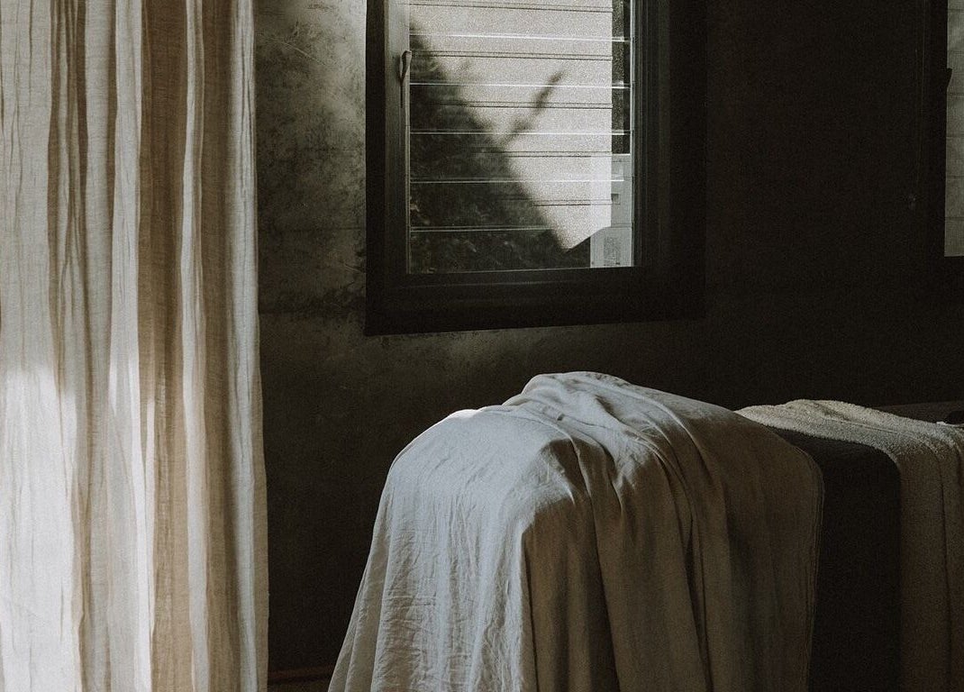 Tranquil massage room at UMICA, Byron Bay, New South Wales, AU, with soft natural light and elegant drapery.