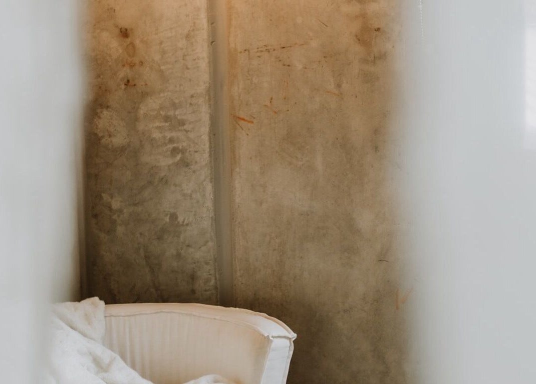 Elegant white chair against a rustic concrete wall at UMICA, Byron Bay, New South Wales, AU.