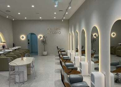 Elegant interior of RM The Studio in Melbourne, Victoria, AU, showcasing modern salon chairs and arched mirrors.