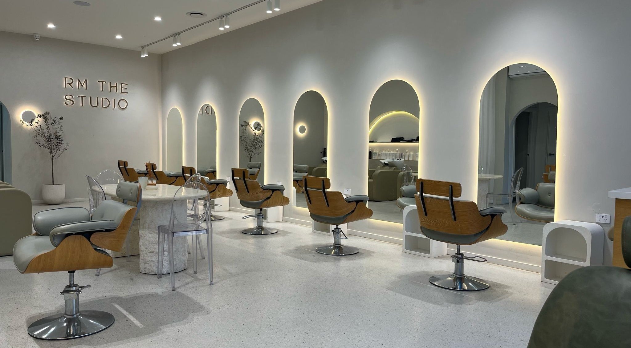 Elegant interior of RM The Studio in Melbourne, Victoria, AU with modern salon chairs and lit mirrors.