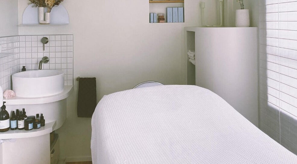 Calm treatment room at Innerbloom Holistic Skin Studio, Auckland, Auckland, NZ. Features a massage bed and sink.