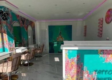Vibrant interior of Hairbyneveswan salon in Dundee, Scotland, GB with colorful walls and modern styling chairs.