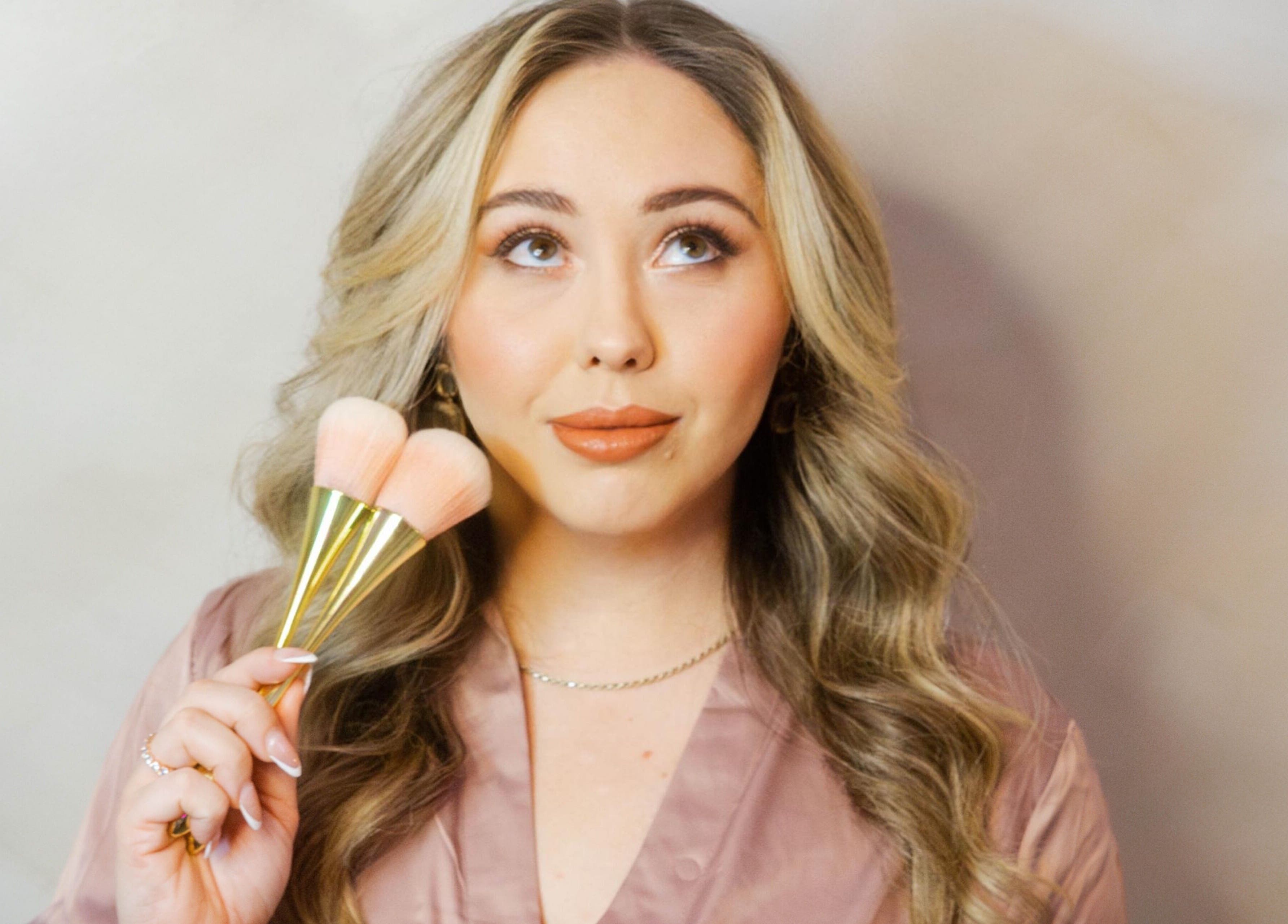 Woman holding makeup brushes at Angel Aesthetics by Angelina, Biloxi, Mississippi, US.