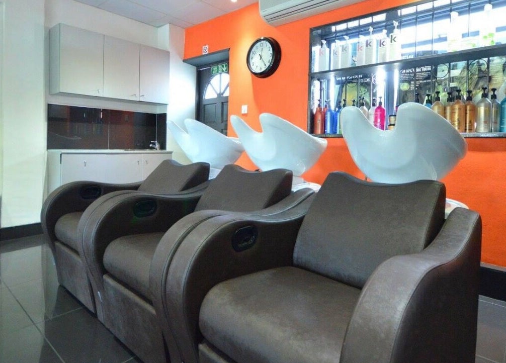 Modern salon chairs and wash basins at Italian Inspiration, Woking, England, GB. Bright and inviting decor.