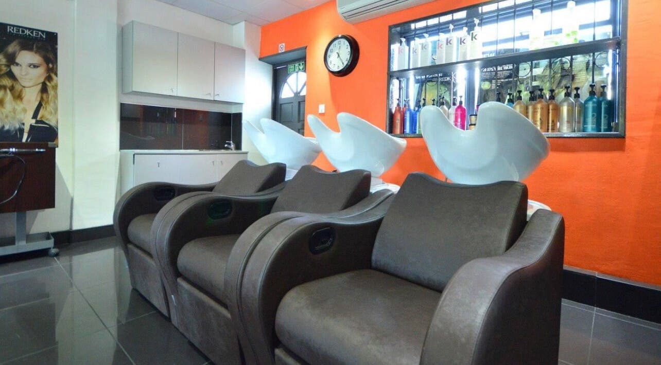 Modern salon chairs and wash basins at Italian Inspiration, Woking, England, GB. Bright and inviting decor.