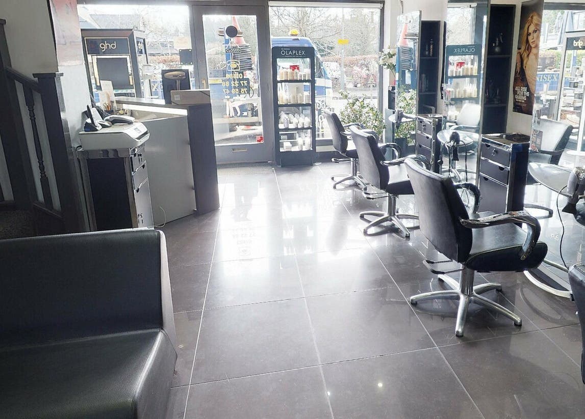 Bright interior of Italian Inspiration salon in Woking, England, GB with chic styling chairs and large mirrors.