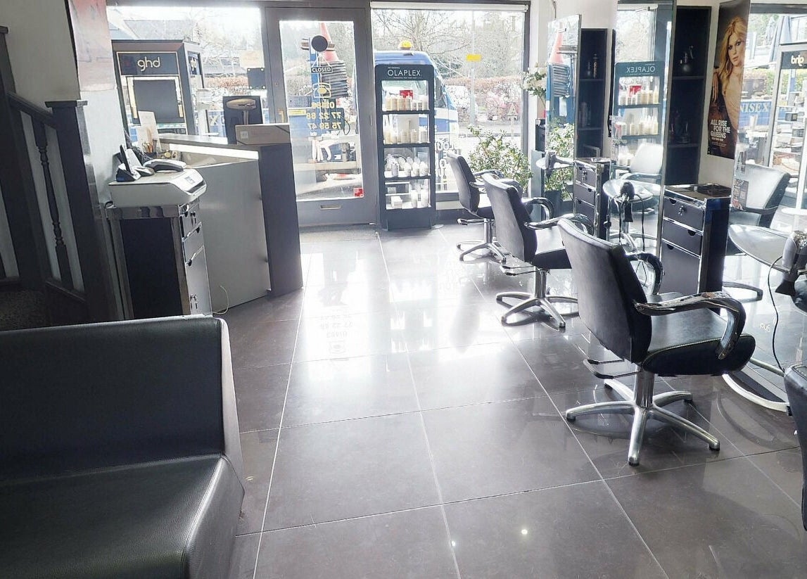 Bright interior of Italian Inspiration salon in Woking, England, GB with chic styling chairs and large mirrors.