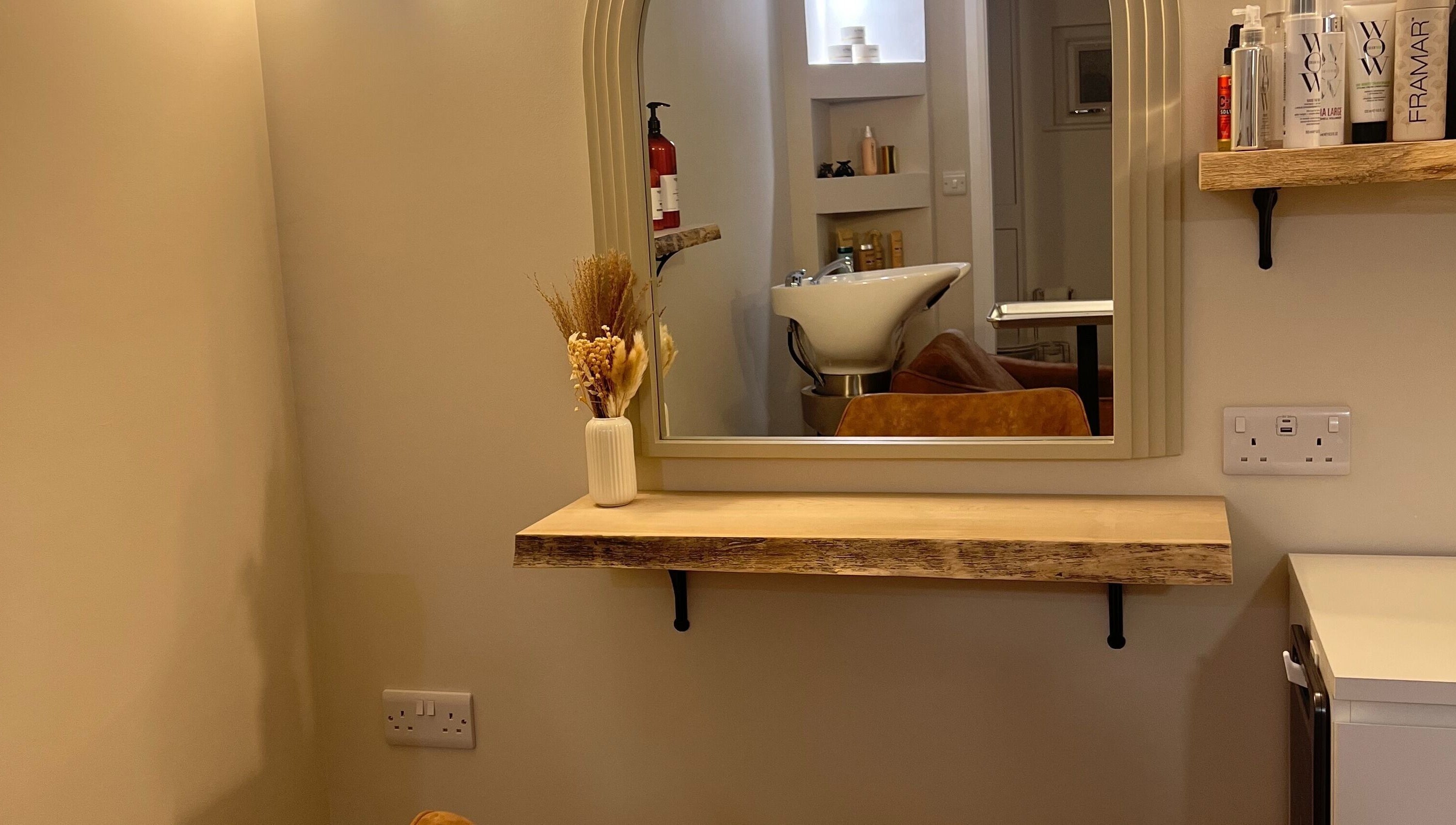 Chic salon mirror and sink at Olivia Fay, Epworth, England, GB. Elegant decor with beauty products displayed.