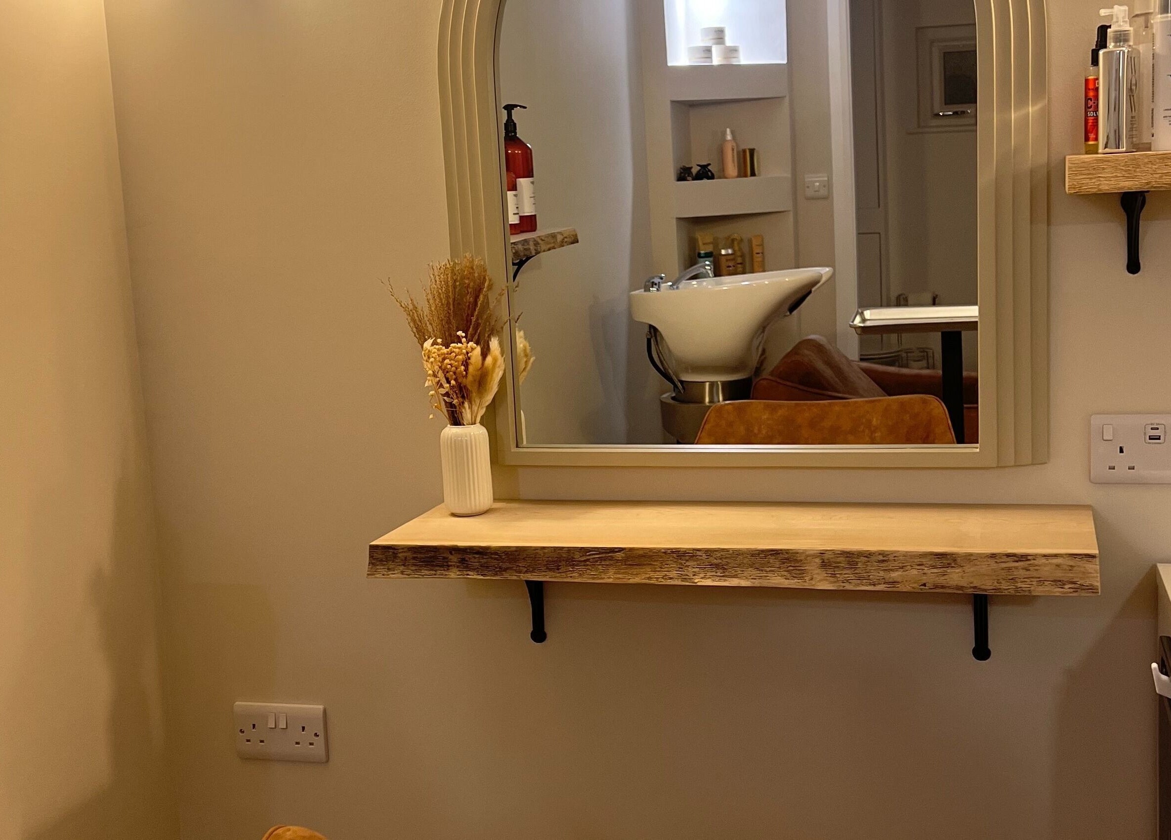Chic salon mirror and sink at Olivia Fay, Epworth, England, GB. Elegant decor with beauty products displayed.