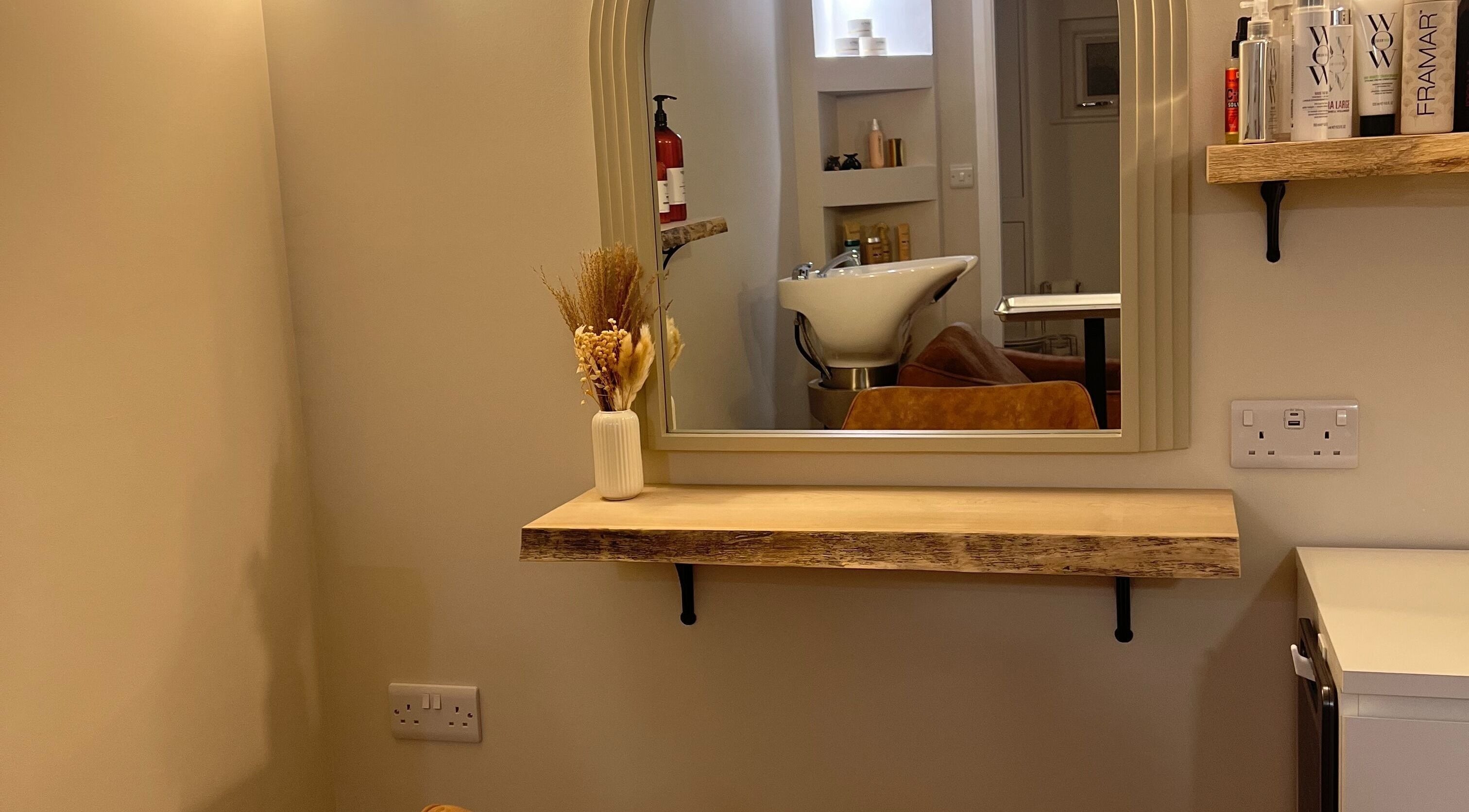 Chic salon mirror and sink at Olivia Fay, Epworth, England, GB. Elegant decor with beauty products displayed.