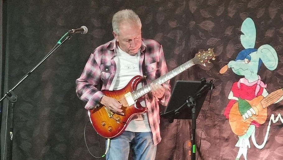 Musician playing guitar at Michael Prizeman Music School, Melbourne, Victoria, AU.
