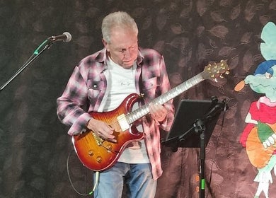 Musician playing guitar at Michael Prizeman Music School, Melbourne, Victoria, AU.