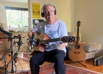 Guitar lesson at Michael Prizeman Music School, Melbourne, Victoria, AU. Cozy setting with guitars and recording gear.