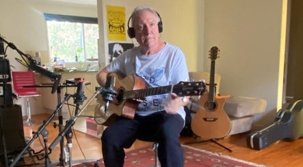 Guitar lesson at Michael Prizeman Music School, Melbourne, Victoria, AU. Cozy setting with guitars and recording gear.