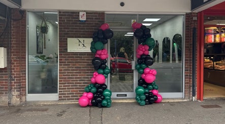 Front entrance of NJ Beauty & Aesthetics in Cowplain, England, adorned with colorful balloons.