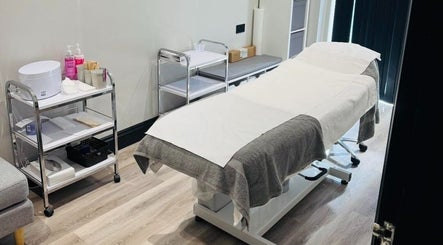 Treatment room at NJ Beauty & Aesthetics in Cowplain, England, GB with a cozy massage table and essentials.