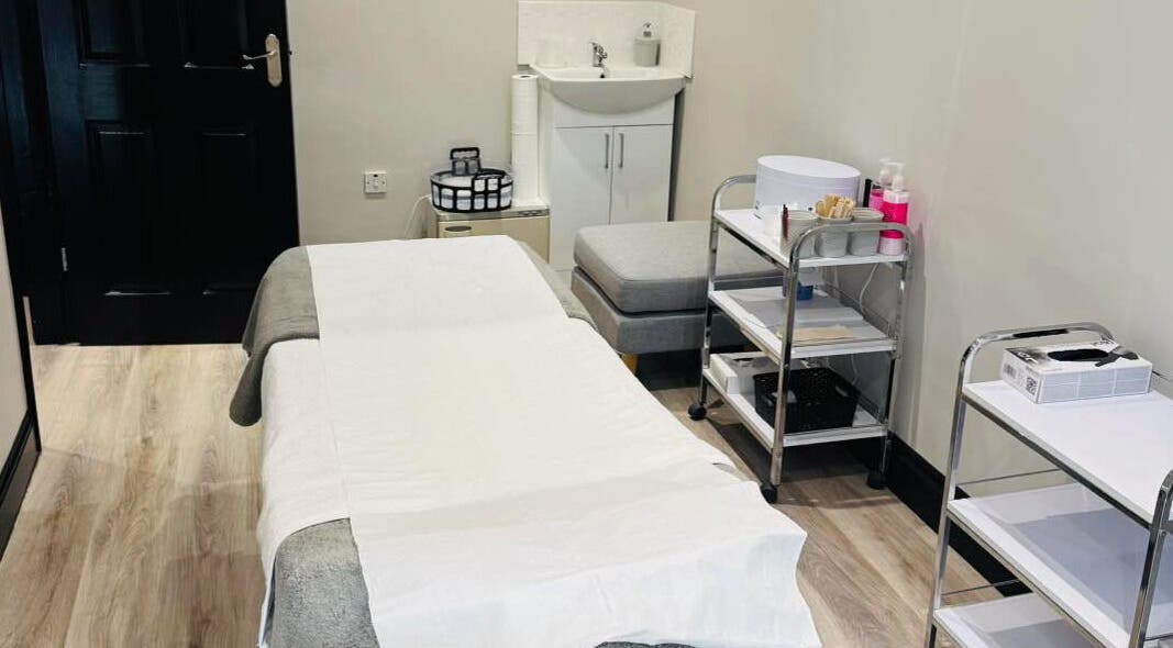 Serene treatment room at NJ Beauty & Aesthetics in Cowplain, England, GB featuring a massage bed and modern decor.