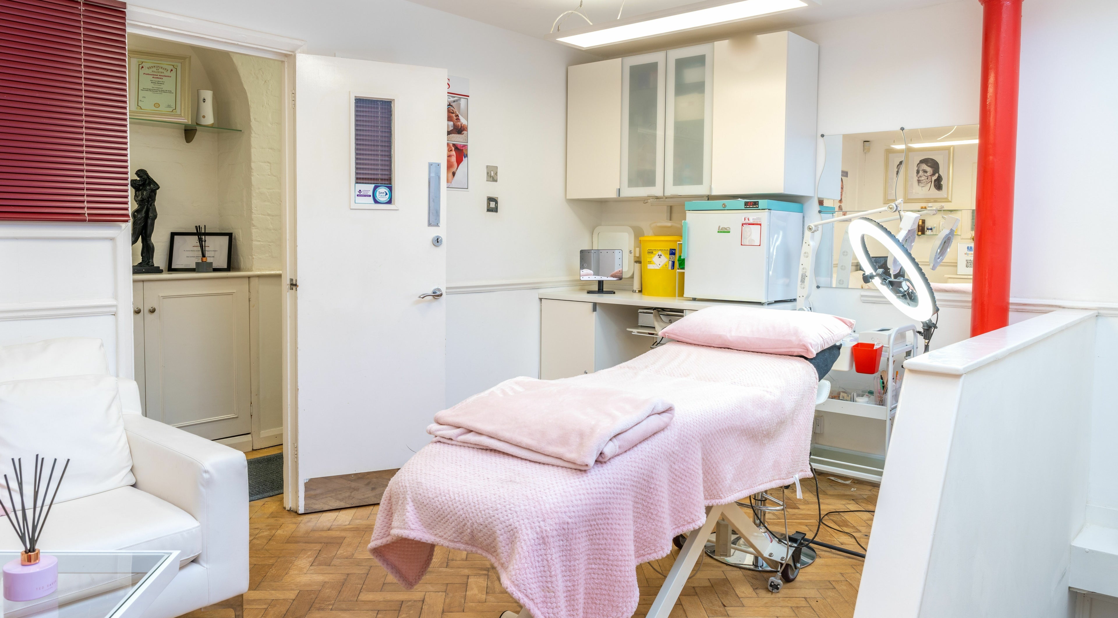 Serene treatment room at Flawless Aesthetics by SB Ltd in Woodford Green, England, GB, with pink accents.