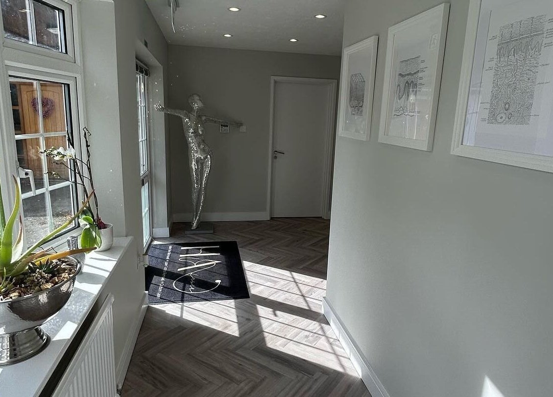 Bright hallway at HA Laser Studio, Basingstoke, England, GB, with art and plants enhancing its serene ambiance.