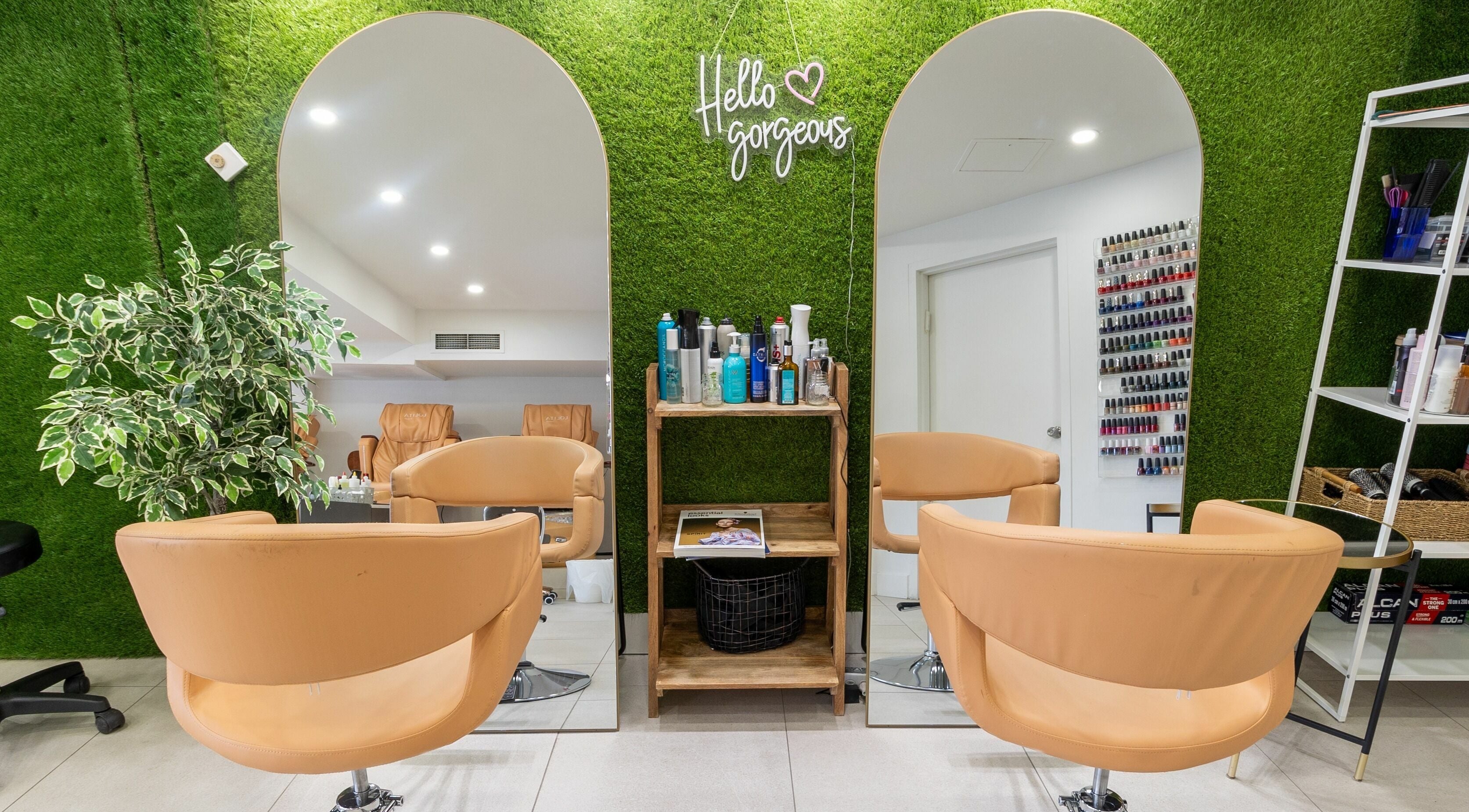 Modern salon setup at Lolita Beaute in Montréal, Québec, CA with chic mirrors, lush greenery, and cozy chairs.